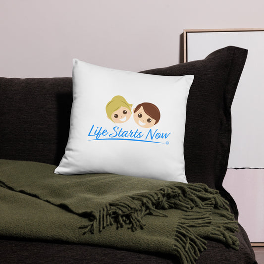 Chic throw pillow featuring the words 'Life Starts Now' placed elegantly on a modern black bed. There's a green blanket beside it