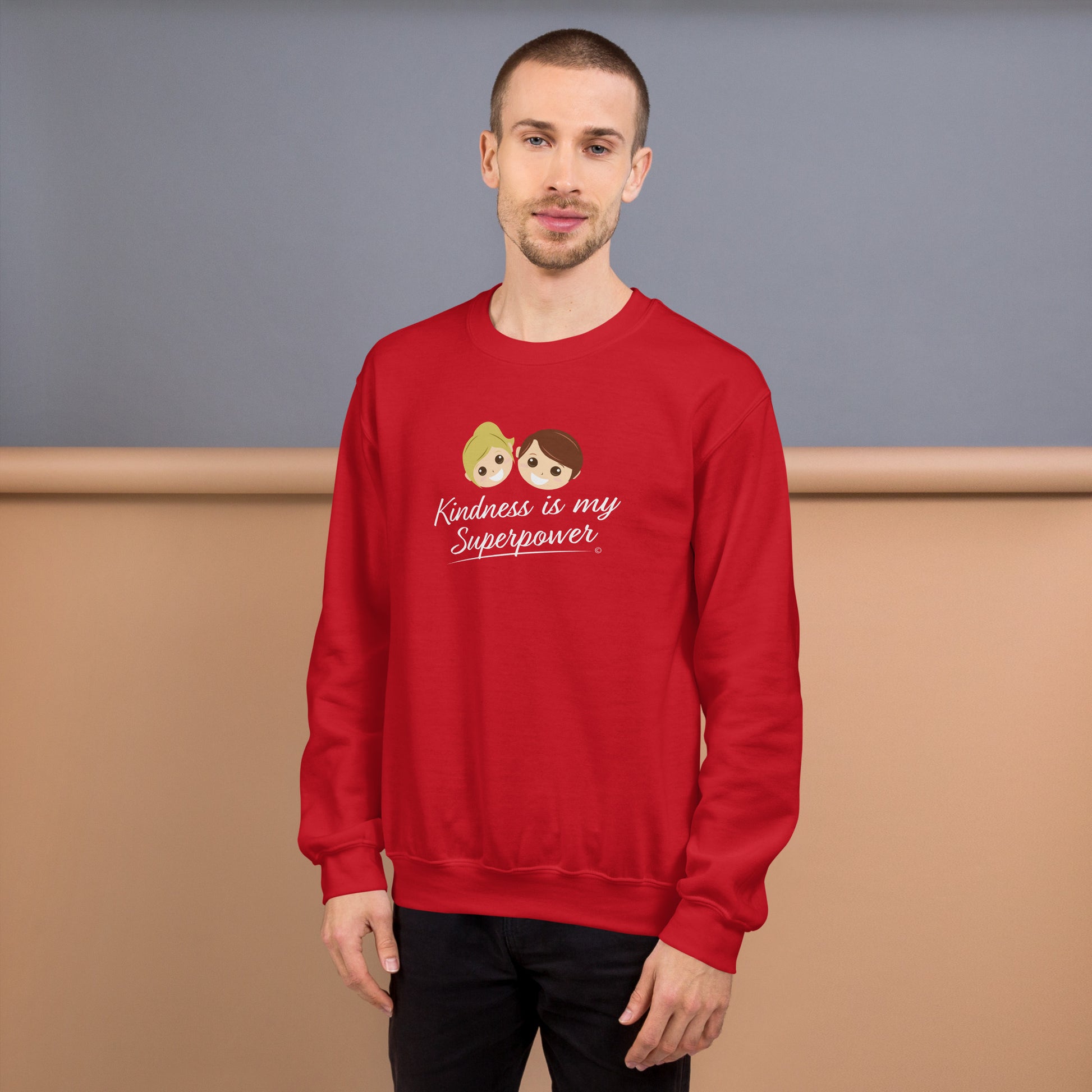 A stylish man confidently modeling a cozy unisex sweatshirt in red, adorned with the empowering quote 'Kindness is my Superpower' in bold lettering.