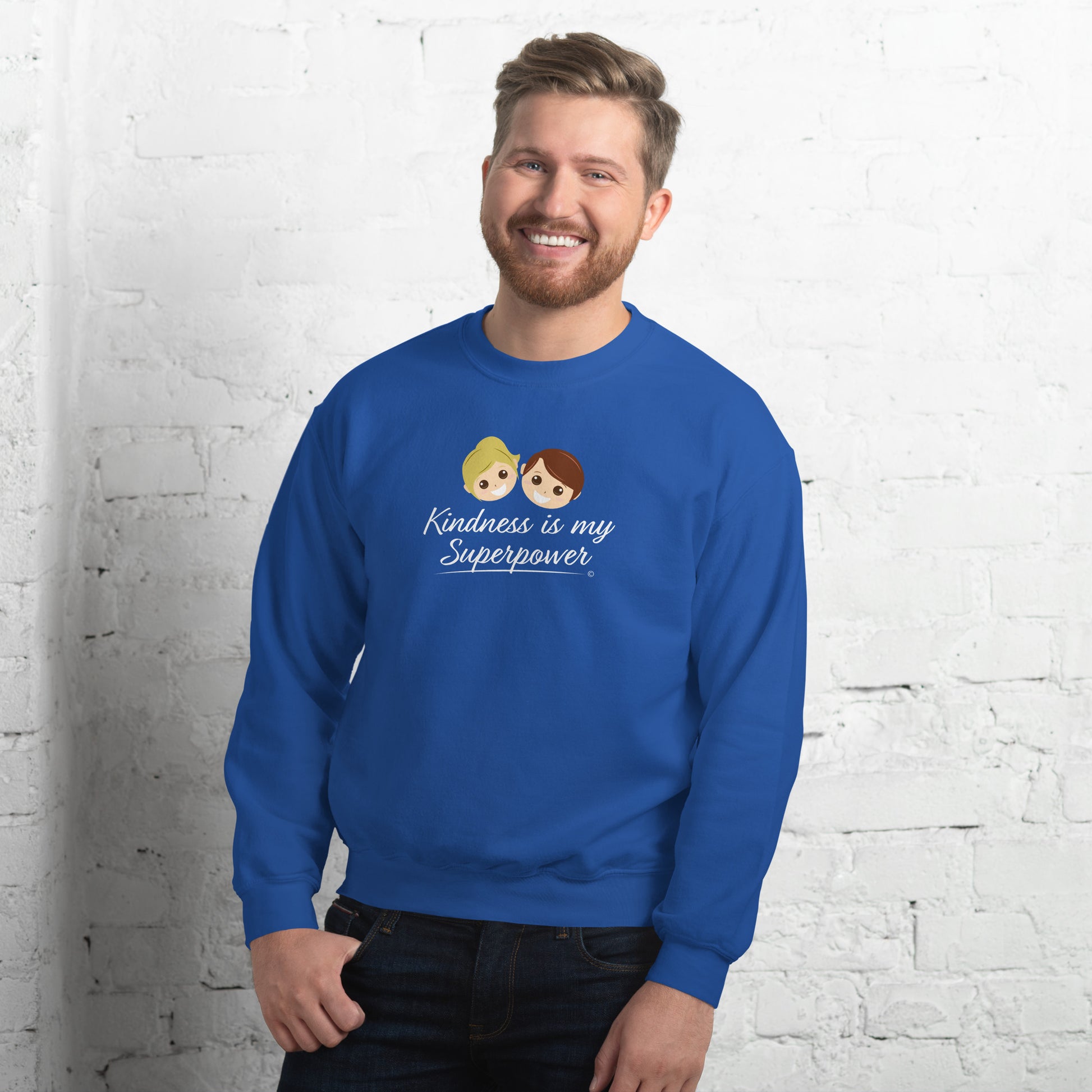 A stylish man confidently modeling a cozy unisex sweatshirt in royal blue, adorned with the empowering quote 'Kindness is my Superpower' in bold lettering.