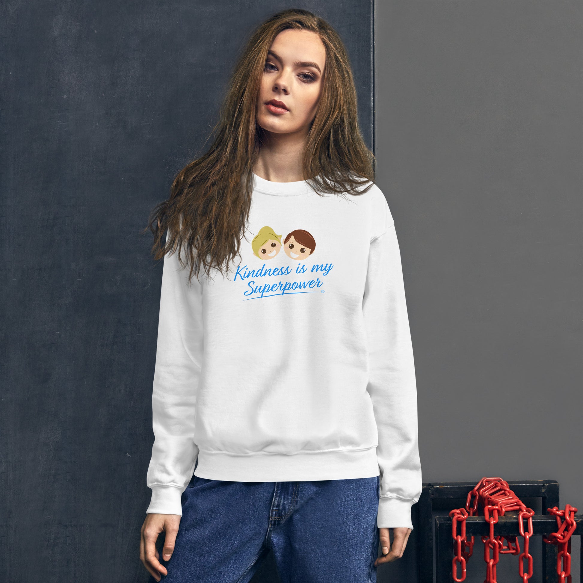 A stylish woman confidently modeling a cozy unisex sweatshirt in white, adorned with the empowering quote 'Kindness is my Superpower' in bold lettering.