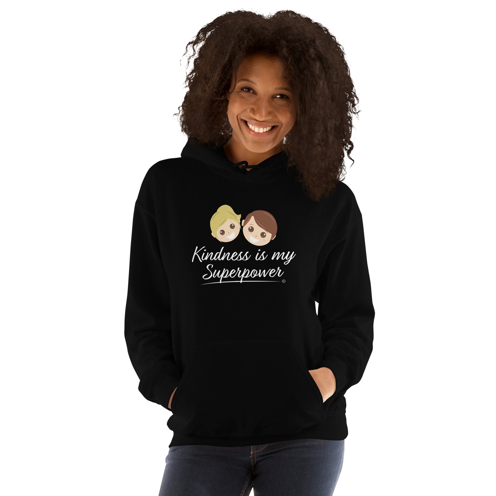 A smiling  woman showcasing a comfortable unisex hoodie in black, featuring the uplifting quote 'Kindness is my Superpower' in bold lettering.