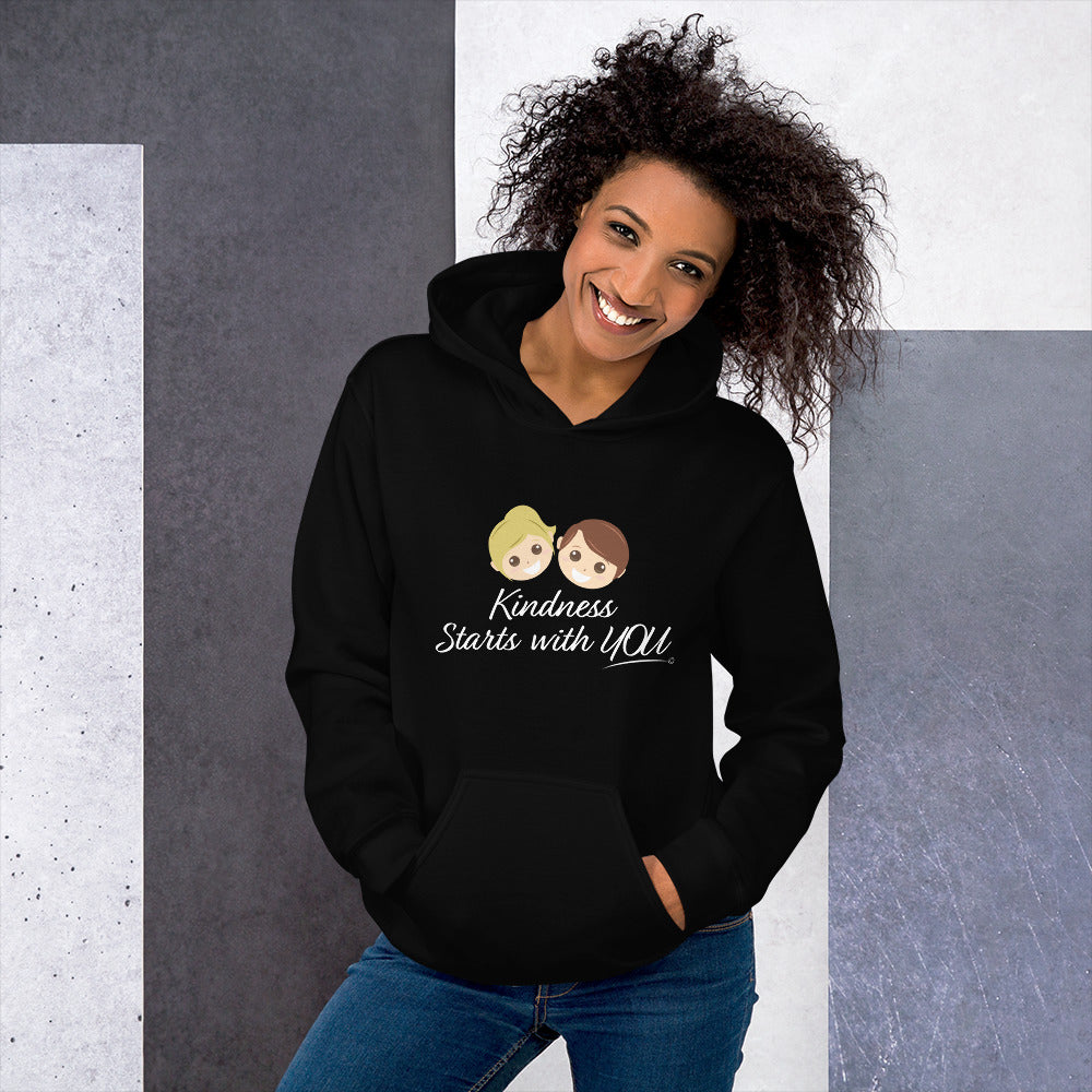A happy woman modeling a cozy unisex hoodie in black, featuring the uplifting quote 'Kindness Starts with You' in bold lettering.
