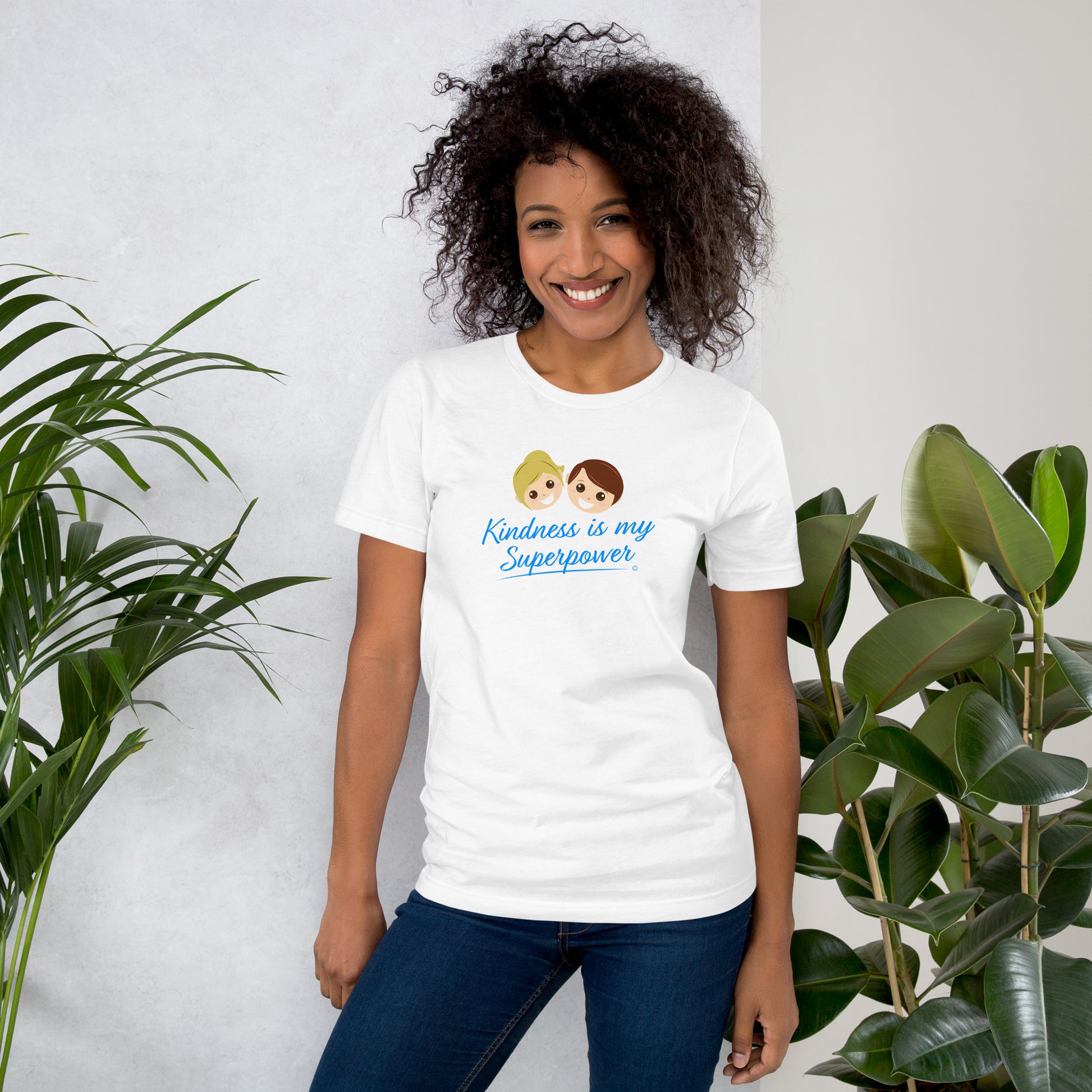 A smiling  woman wearing a white shirt with the empowering quote 'Kindness is my Superpower' in bold lettering.